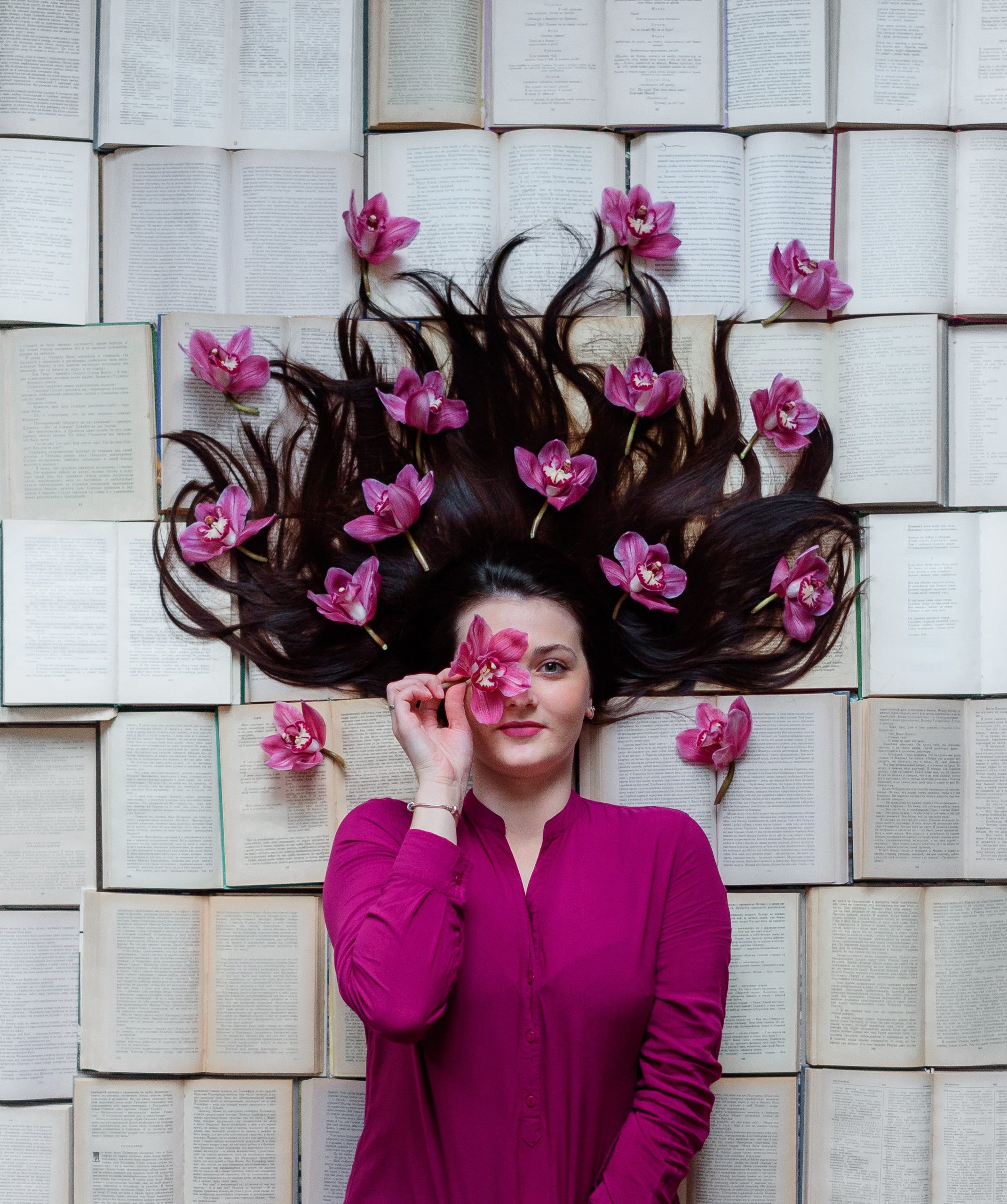 girl-is-lying-opened-books-fressed-fuchsia-blouse-with-magnolia-flowers-hair-min